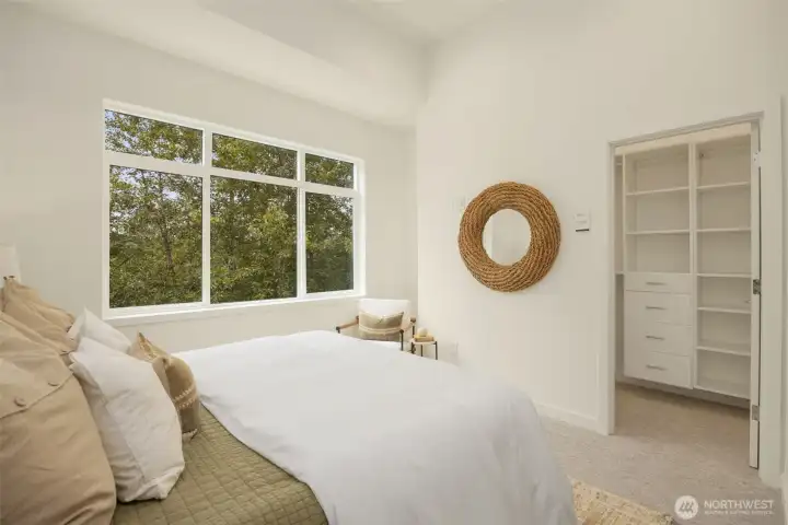 Another look at the generous primary suite, emphasizing the soaring ceilings, clean architectural lines, and ample room for a king-sized layout.