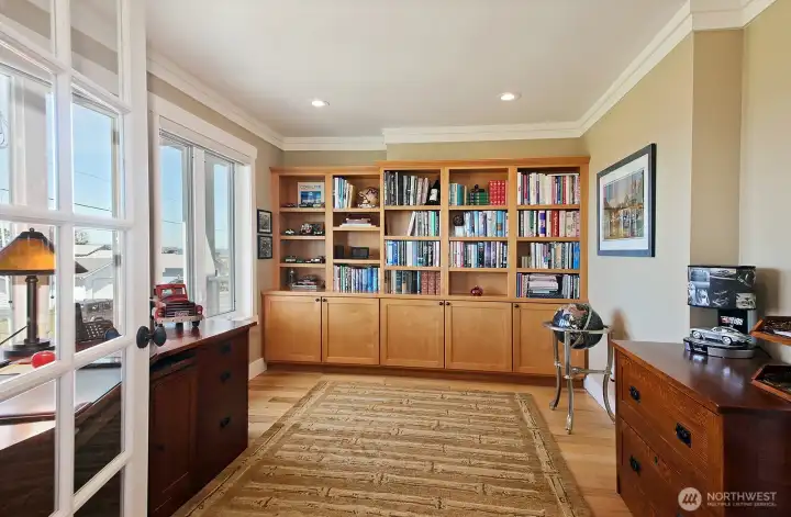 Office with built in cabinets, water view & French doors.