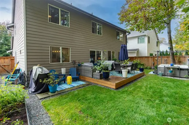 Back exterior with a deck, patio, and hot tub for your entertaining and relaxing needs.