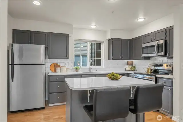 Kitchen w/ Quartz Countertops & tiled backsplash