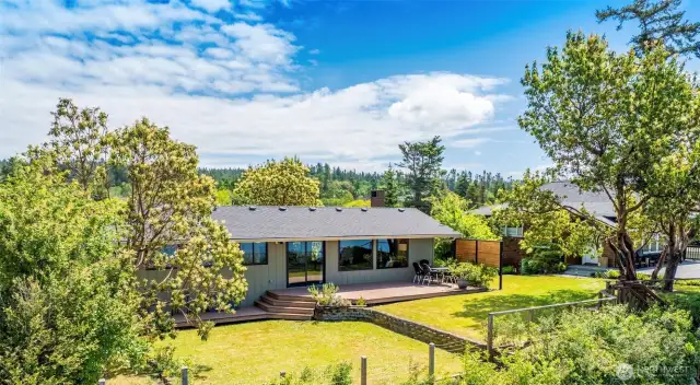 Framed by the graceful presence of Madrona trees, the home feels rooted in nature.
