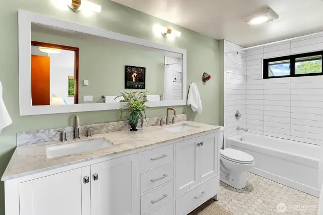 Primary bath was completely remodeled with marble countertops, marble hex floor tiles and stacked subway around the tub with a niche.