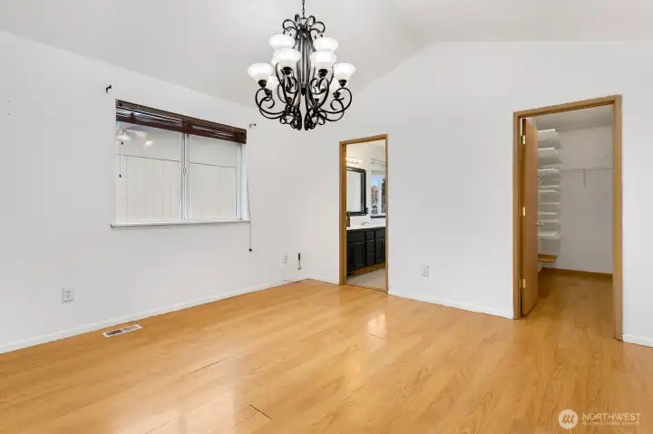 Primary bedroom with vaulted ceilings, en suite bath, and walk-in closet.