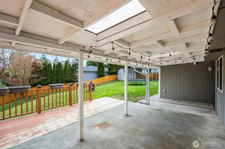 Covered cement patio that leads to the back deck