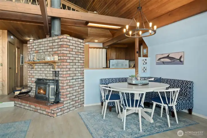 Entry hall to left, cozy fireplace for cooler days, delightful dining alcove with kitchen behind.