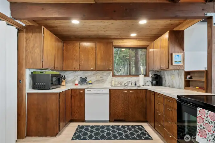 Updated kitchen with solid counters opens to great room on right.