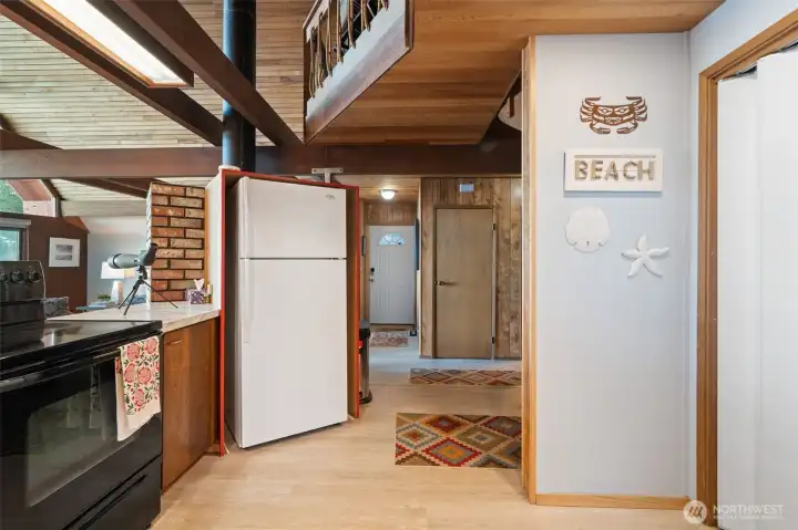 Kitchen to entry door/hallway.  Washer/dryer on left.