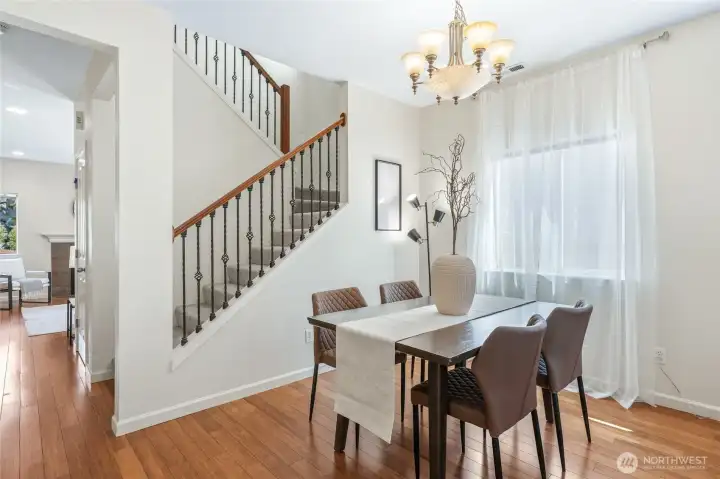 Dining area, beautiful wrought iron staircase, and peek into the kitchen beyond.