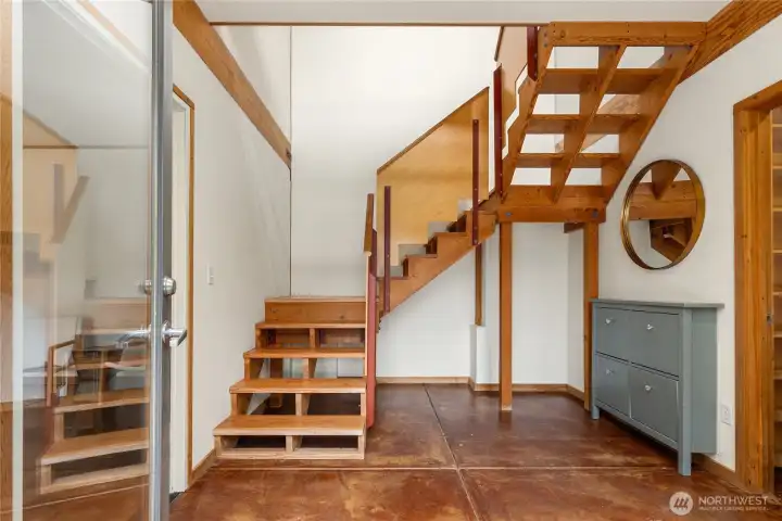 Welcoming entry with open stair, concrete floors. Welcoming entry with open stair, concrete floors.