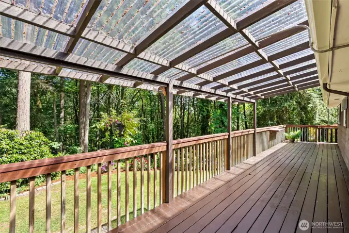 The expansive deck is mostly covered and has peaceful views to the back yard and forest.