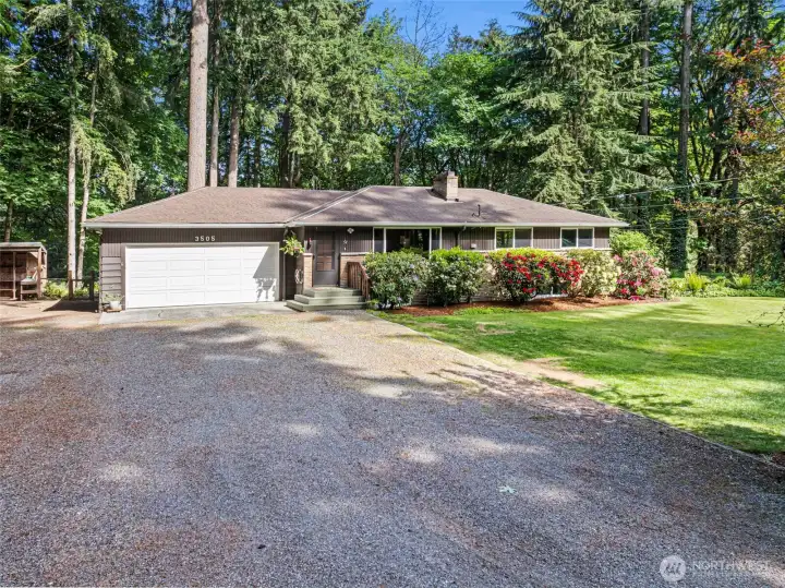 Mature landscaping decorates this yard beautifully.