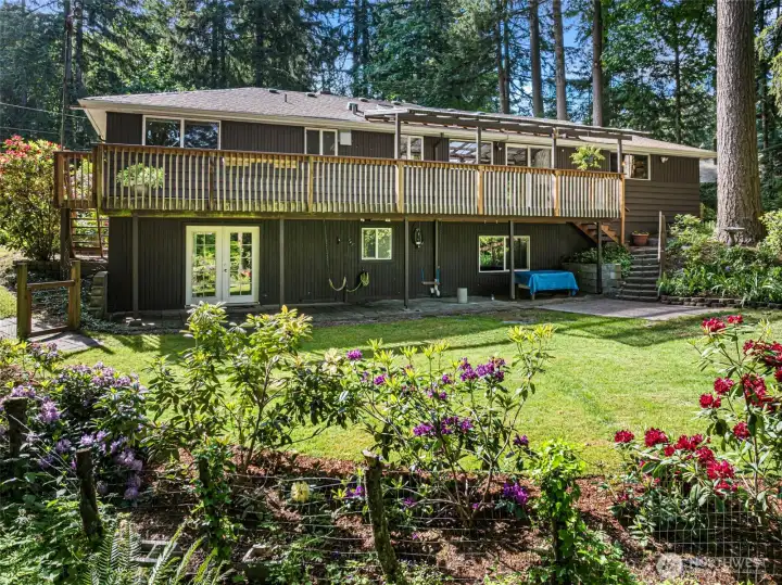 The back of the home with expansive deck and easy access to the lower level.