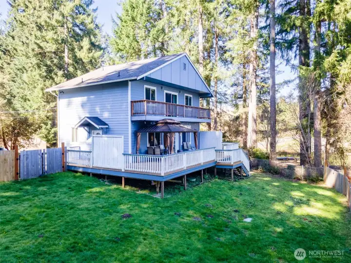 Exterior rear view of lakefront home and backyard