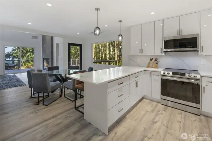 An open-concept layout connects the kitchen, dining area, and living room, creating an effortless gathering space for entertaining on Lopez Island. An open-concept layout connects the kitchen, dining area, and living room, creating an effortless gathering space for entertaining on Lopez Island.