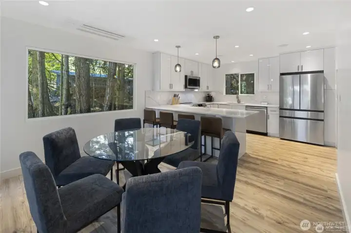 The dining area sits beside the beautifully updated kitchen, framed by large windows that bring the surrounding trees and island light indoors. The dining area sits beside the beautifully updated kitchen, framed by large windows that bring the surrounding trees and island light indoors.