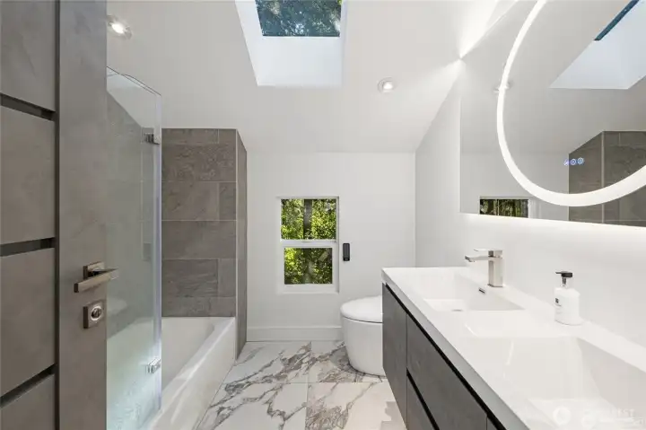 Sleek cabinetry, contemporary tile, skylight, and refined fixtures create a polished full bath designed for comfort, style, and everyday convenience. Sleek cabinetry, contemporary tile, skylight, and refined fixtures create a polished full bath designed for comfort, style, and everyday convenience.