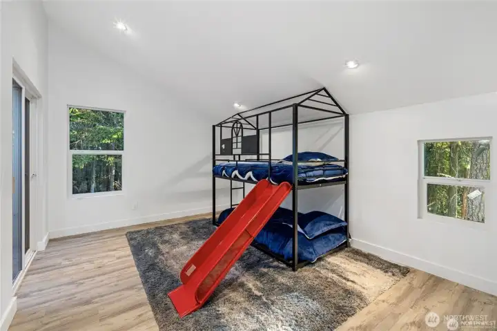 A versatile guest bedroom provides room for family, visitors, or creative use, with vaulted ceilings, large windows, and a modern, move-in ready finish. A versatile guest bedroom provides room for family, visitors, or creative use, with vaulted ceilings, large windows, and a modern, move-in ready finish.