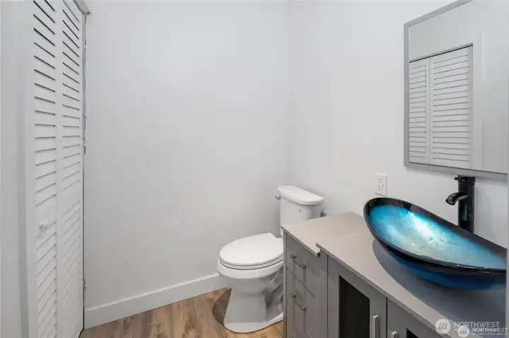 This updated half bath adds everyday convenience with a distinctive blue glass vessel sink, modern vanity, and fresh contemporary styling. This updated half bath adds everyday convenience with a distinctive blue glass vessel sink, modern vanity, and fresh contemporary styling.