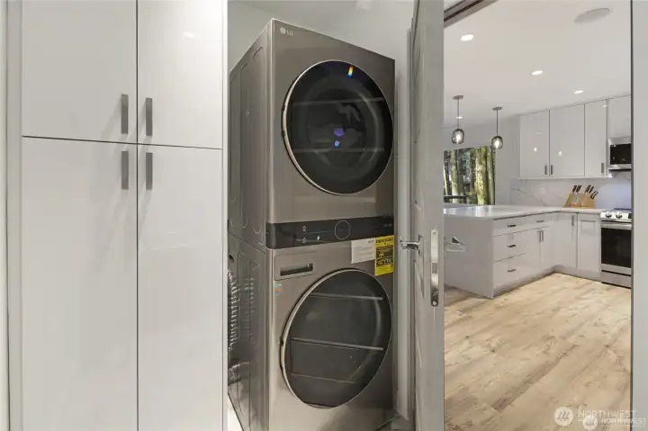 Convenient laundry space with a stacked washer and dryer sits near the kitchen, offering practical everyday ease within the home’s updated layout. Convenient laundry space with a stacked washer and dryer sits near the kitchen, offering practical everyday ease within the home’s updated layout.