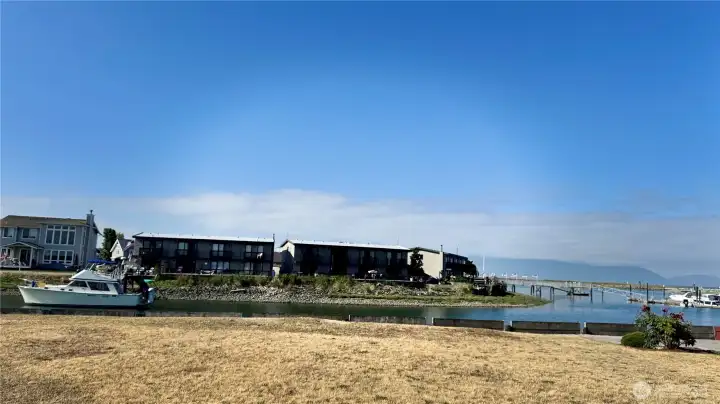 This view is from across the channel towards the West and the townhome is the center unit to the right with the included moorage slip in the docks to the right. Those are to San Juan Islands to the Westerly view. This view is from across the channel towards the West and the townhome is the center unit to the right with the included moorage slip in the docks to the right. Those are to San Juan Islands to the Westerly view.