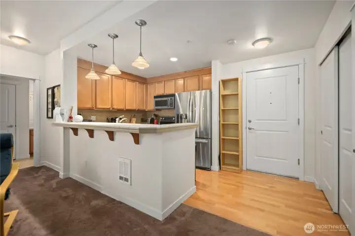 Kitchen with breakfast bar, pantry storage, and stainless steel appliances. Kitchen with breakfast bar, pantry storage, and stainless steel appliances.