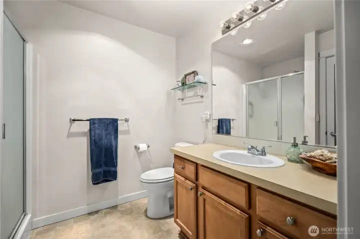 Full bathroom with glass shower doors and neutral finishes. Full bathroom with glass shower doors and neutral finishes.