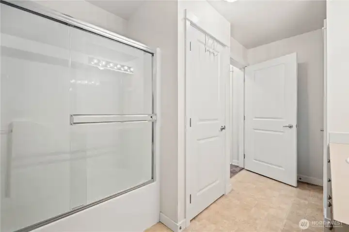 Glass-enclosed shower with nearby linen and closet storage. Glass-enclosed shower with nearby linen and closet storage.