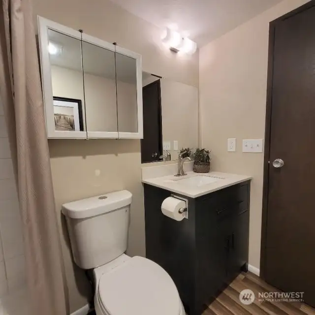 Full bathroom with a new toilet and new flooring