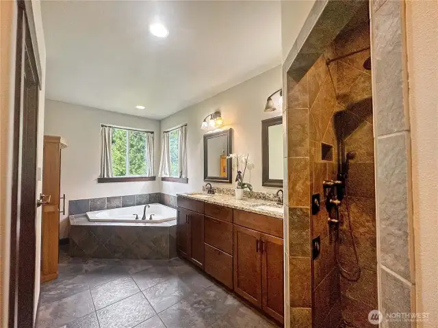 Retreat to the luxurious primary suite with spa-inspired en suite bath, complete with a freestanding soaking tub, oversized walk-in shower, and dual vanities.