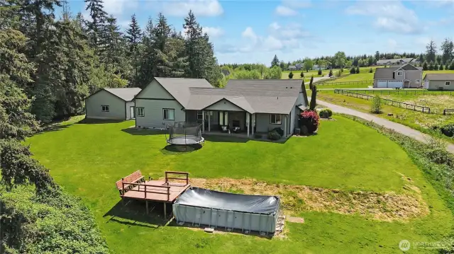 Set on several beautifully landscaped acres, this property offers a stunning blend of manicured grounds and natural beauty.  virtually enhanced grass.