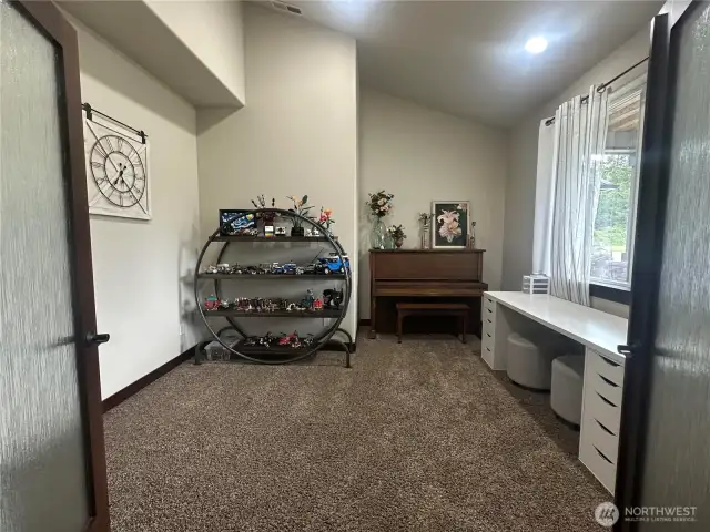 A spacious home office just off the entryway, enclosed by double doors for privacy and sophistication