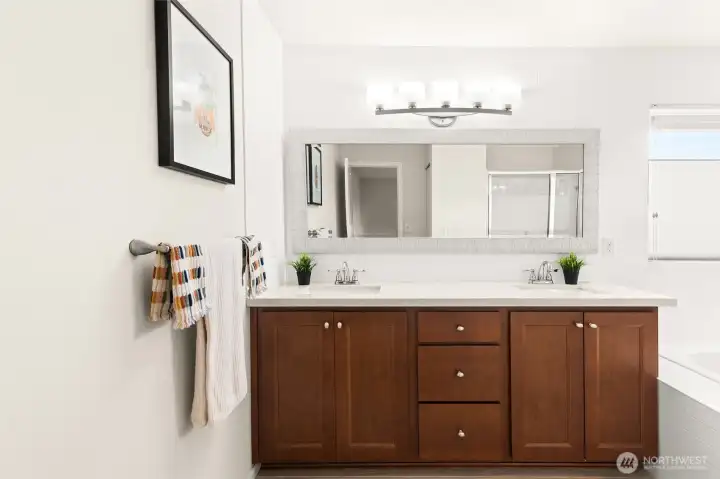 Quartz countertops, hardwood cabinets, and dual sinks.