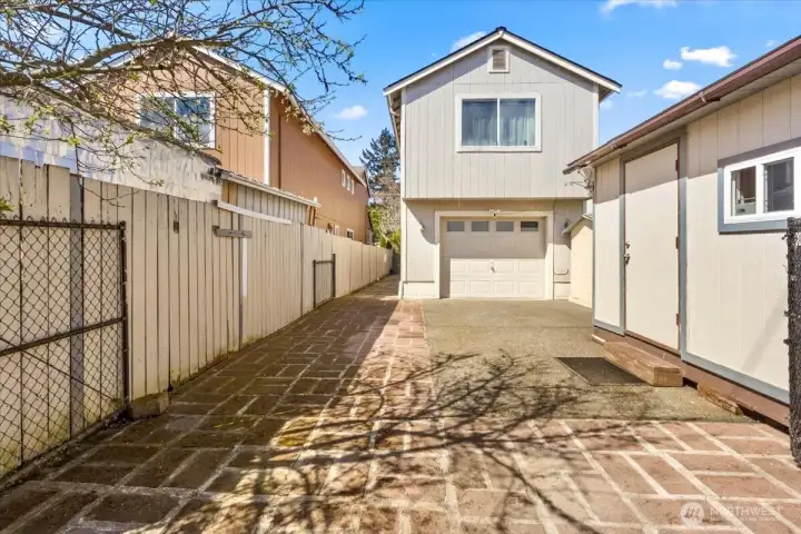 The one-car garage, driveway for parking another car, and detached outbuilding for storage.