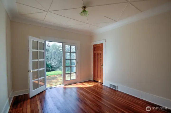 Main floor primary bedroom with custom coved ceilings and large deck