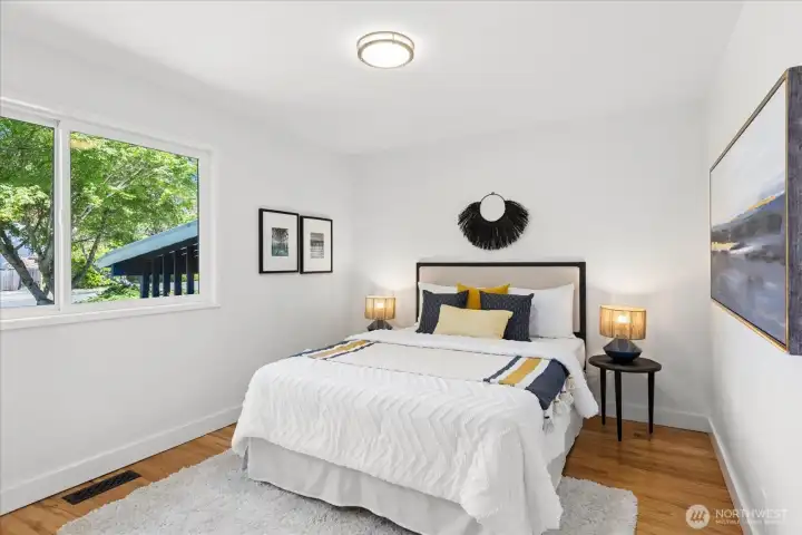 Peaceful primary bedroom with large windows and abundant natural light