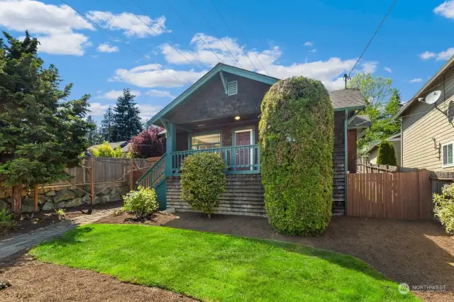Large fenced front yard with mature landscaping
