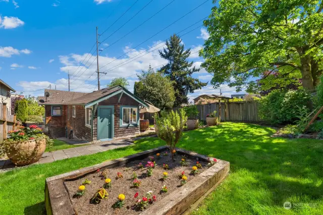 Private fully fenced yard with raised garden beds, patio area and hot tub