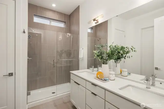 Primary bath with quartz counters, duel undermount sinks, large shower with designer selected tile.  Photos are for illustrative purposes