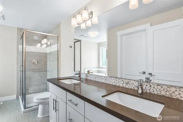 Primary bath with newer white cabinets, Quartz surface and tiled shower.