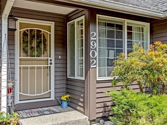Welcoming front door includes a secure screen door to allow nice air flow through the home.