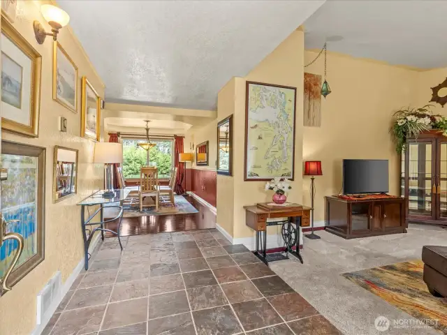 The entry of the home has a beautiful slate tiled floor. So easy to keep well-maintained.  The vaulted living room is off to the right.  This home enjoys a formal livingroom, a family room off the kitchen and a Rec room downstairs.