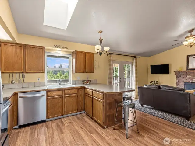 The spacious, bright kitchen awaits. Bar seating for 4 makes meal time quick and easy if you want it to be.  Newer flooring, skylights. Stainless steel appliances.  All appliances stay.