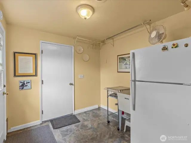Utility room leading into the garage.  The washer and dryer are located directly inside the garage.  There is also a side door leading into the yard on the side of the house where the shed is located.