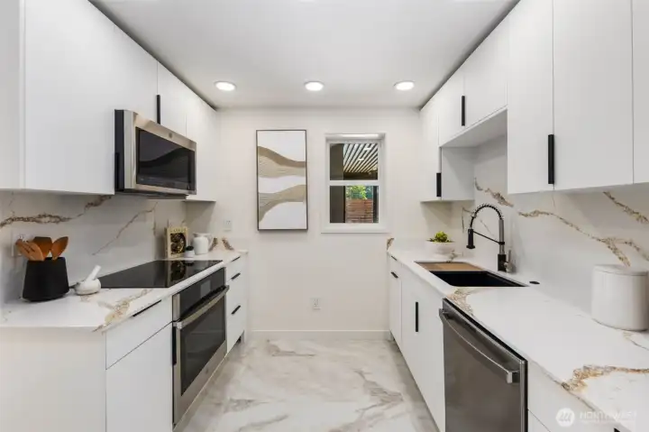 Quartz countertops with full-height backsplash and stainless appliances deliver both style and performance in this brand new kitchen.