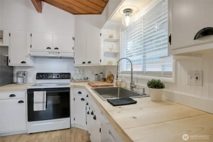 New hardwood counter tops, kitchen sink and faucet, range hood and a fresh coat of paint make for a kitchen ready to cook in.