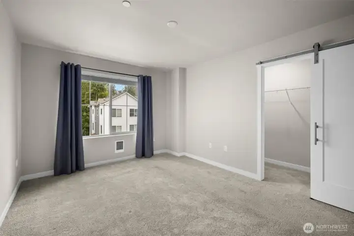 Primary walk in closet w/barn door gives this room a functional and elegant look.