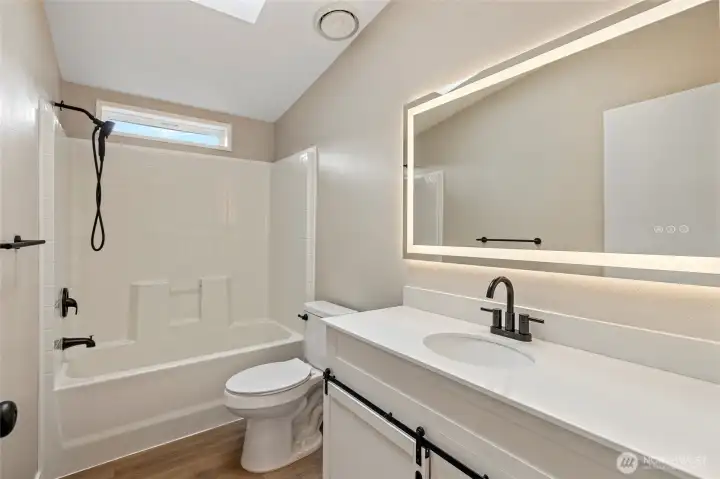 Hall bathroom with lit LED mirror