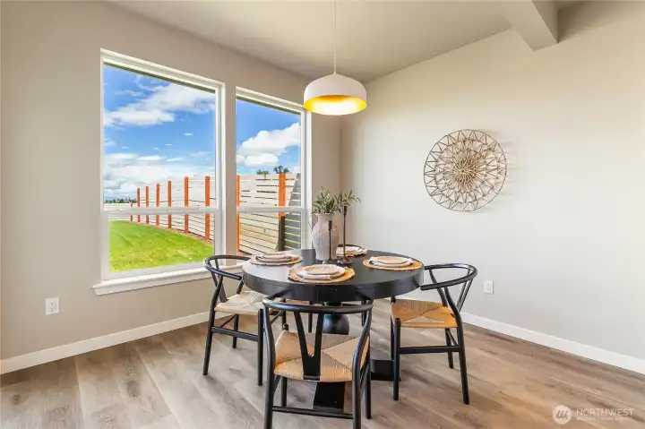 Dining area sits in front of large windows giving you a view of the grassy backyard