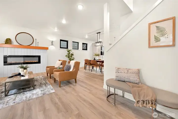 Sunlit living room filled with natural light. Features an elegant built-in electric fireplace.