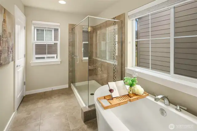 Primary bathroom with standalone tub, separate shower, and spacious closet.